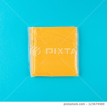American cheese, processed cheese slice, wrapped thin yellow cheddar in a plastic package American cheese, processed cheese slice, wrapped thin yellow cheddar in a plastic package 123674980