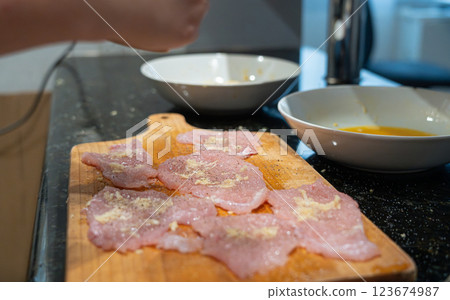 Peppering of tenderized meat for schnitzel Peppering of tenderized meat for schnitzel 123674987