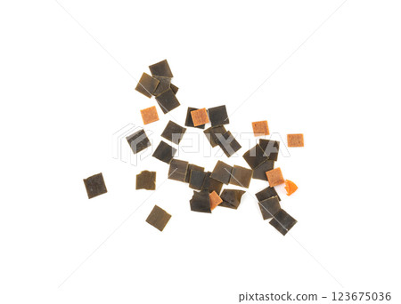 Dry kelp seaweed squares, mini wakame pieces isolated, dried kombu and carrot flakes from ramen Dry kelp seaweed squares, mini wakame pieces isolated, dried kombu and carrot flakes from ramen 123675036