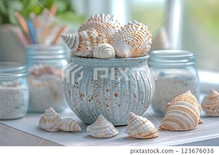 Ceramic pot filled with seashells, surrounded by glass jars with sand, set on a wooden surface in natural light Ceramic pot filled with seashells, surrounded by glass jars with sand, set on a wooden surface in natural light 123676038