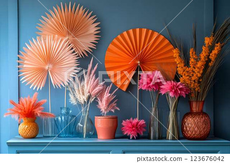 Elegant display of decorative paper fans and dried flowers in glass vases against a deep blue wall Elegant display of decorative paper fans and dried flowers in glass vases against a deep blue wall 123676042