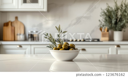 A traditional kitchen with a bowl of olives and an olive branch on the countertop.  123676162