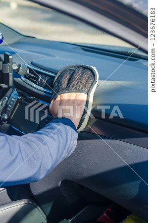 Hand Cleaning Car Dashboard with a Soft Microfiber Mitt for Interior Maintenance. High quality photo Hand Cleaning Car Dashboard with a Soft Microfiber Mitt for Interior Maintenance. High quality photo 123676183