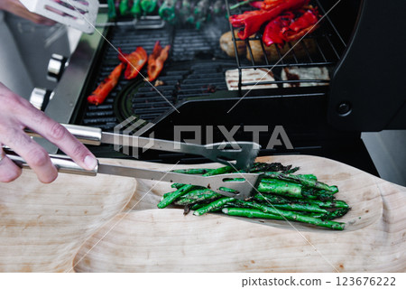 asparagus on wooden plate. . Delicious grilled vegetables asparagus and paprika on barbecue grill with smoke and flame. 123676222