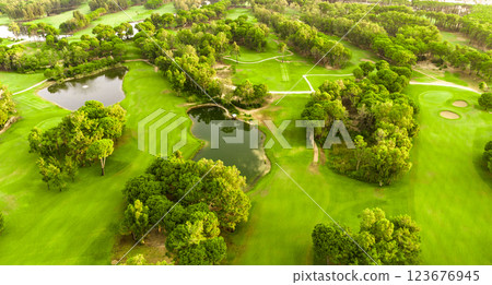 Aerial view of a golf course with lakes, sand bunkers, and tree-lined fairways 123676945