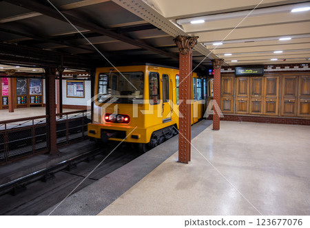 Budapest, Hungary, August 30, 2022. Old metro M1 stop. The yellow train is moving away from the platform. Vintage lines and style perfectly preserved. 123677076