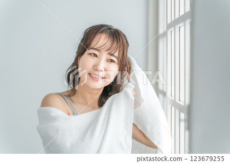 An Asian woman who towel-dries her hair after taking a bath and shampooing in the morning An Asian woman who towel-dries her hair after taking a bath and shampooing in the morning 123679255