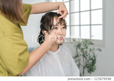 一名婦女和一名理髮師在美容院、理髮店或髮廊接受治療 123679596
