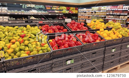Fresh green, red, and yellow peppers displayed in grocery store produce section Fresh green, red, and yellow peppers displayed in grocery store produce section 123679730