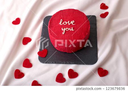 Red heart-themed cake with love message on slate board 123679836