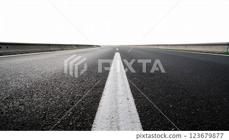 Top down view of a minimalistic asphalt road with dashed lane markings and solid border lines on a white background, the texture of the road and the simplicity of transportation infrastructure 123679877