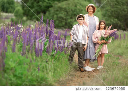 Family stroll in purple flowers field with caucasian adult female and two children Family stroll in purple flowers field with caucasian adult female and two children 123679968