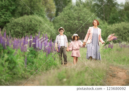 Happy caucasian family walking in flower field with children in summer Happy caucasian family walking in flower field with children in summer 123680092
