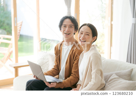 一對夫婦坐在沙發上看電腦 123680210