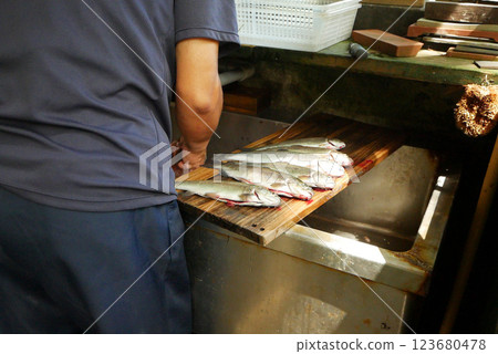 A person who prepares fish at a fishing spot A person who prepares fish at a fishing spot 123680478