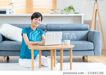 A woman working from home in the living room. 123681198
