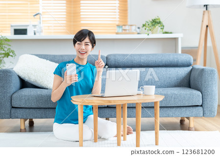A woman working from home in the living room. 123681200