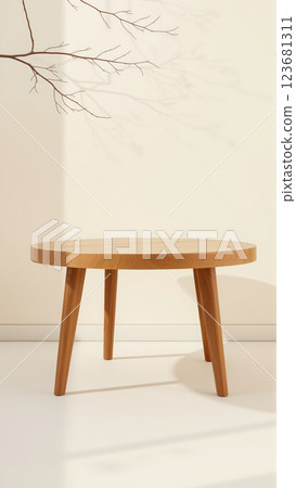 A simple wooden table with a round top filled with a coating that provides sunlight. The delicate shadows of leafy branches play on the textured cream wall in the background. 123681311