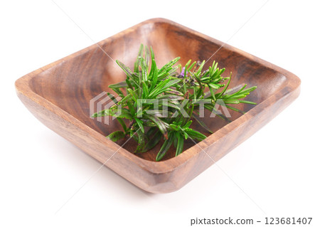 Organic rosemary twig in wood bowl isolated on white background. 123681407