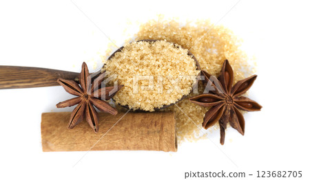 Aromatic brown sugar in a wooden spoon paired with star anise and a cinnamon stick. Aromatic brown sugar in a wooden spoon paired with star anise and a cinnamon stick. 123682705