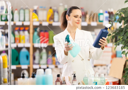 Adult woman chooses cleaning spray in store 123683185