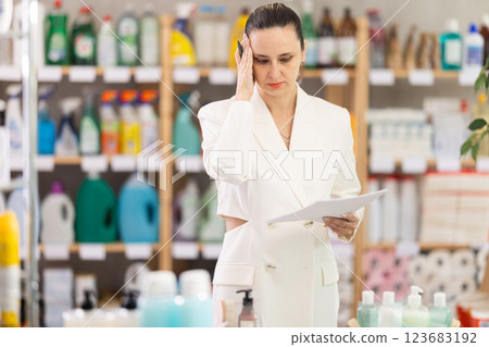 Anxious woman seller with checklist in store 123683192