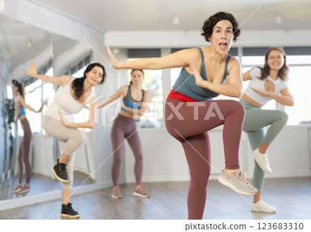 Active females exercising dance moves in modern dance studio 123683310