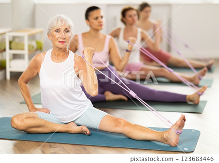 Elderly woman exercising with pilates loop 123683446
