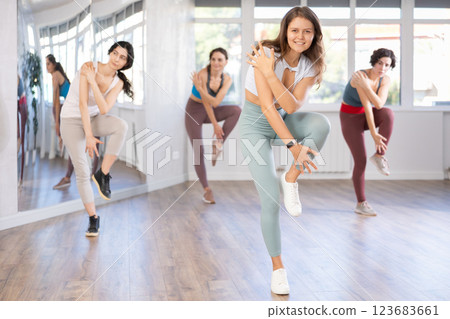 Emotional female dancer rehearsing popping techniques during group workout Emotional female dancer rehearsing popping techniques during group workout 123683661