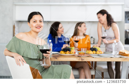 Happy Kazakh girl sitting in front of friends group, with her back to speakers. 123683730