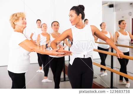 Various aged women exercising ballet moves with trainer 123683738
