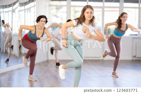 Smiling young woman enjoying vigorous dance at group class 123683771