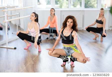 Group of women in high heels dances on floor Group of women in high heels dances on floor 123683820