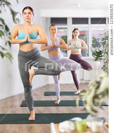 Three women doing yoga in fitness studio Three women doing yoga in fitness studio 123683870