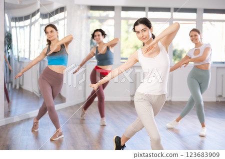 Enthusiastic young woman learning dynamic dances at choreography class Enthusiastic young woman learning dynamic dances at choreography class 123683909