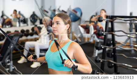 Young woman training with straps in gym 123683913