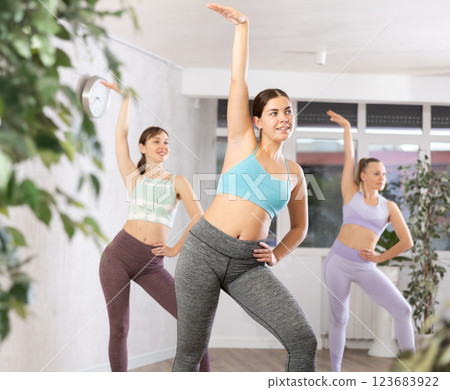 Sporty women learning aerobic dances in wellness center Sporty women learning aerobic dances in wellness center 123683922