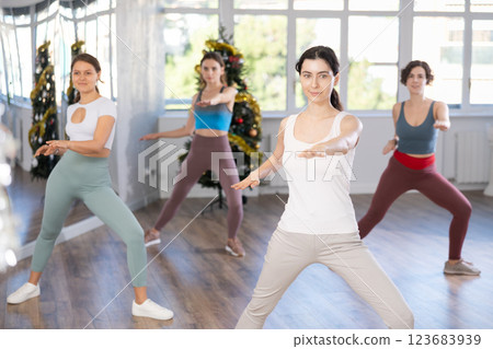 Slender young women dancers dance a swing steps in modern way during the Christmas celebration Slender young women dancers dance a swing steps in modern way during the Christmas celebration 123683939