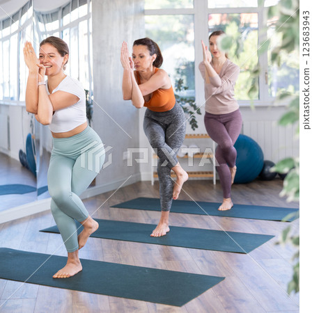 Girl performing Garudasana, or Eagle Pose, at group yoga class 123683943