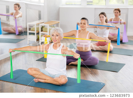 Elderly woman exercises with pilates band Elderly woman exercises with pilates band 123683973