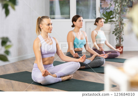 Three women doing yoga in fitness studio 123684010