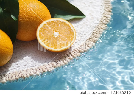 Creative summer composition made of sliced orange in transparent pool water. Refreshment concept. Healthy refreshing drink theme. Top view 123685210