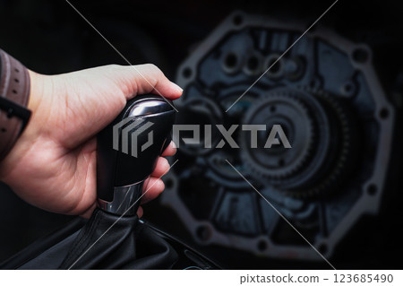 Automatic gearshift lever and transmission with blurred metal gears on dark background 123685490