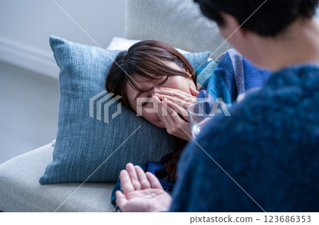 A woman who has caught a cold and is being nursed A woman who has caught a cold and is being nursed 123686353