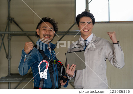 A man doing a guts pose in work clothes A man doing a guts pose in work clothes 123686356