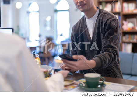 男顧客用智慧型手機付款，女店員沒有臉 123686468