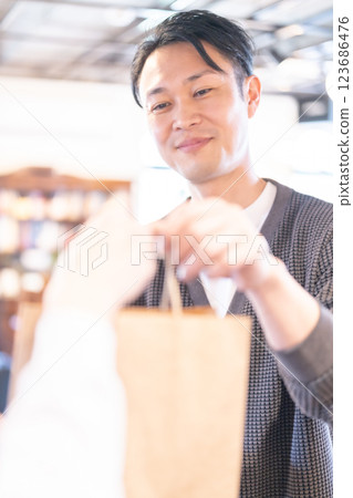 A smiling restaurant clerk handing over the product A smiling restaurant clerk handing over the product 123686476