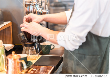 年輕的咖啡師在咖啡館工作,沒有臉 年輕的咖啡師在咖啡館工作,沒有臉 123686483