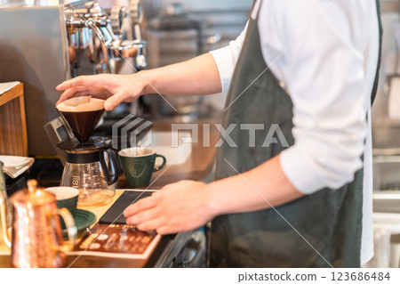 Young barista working at a cafe, no face 123686484