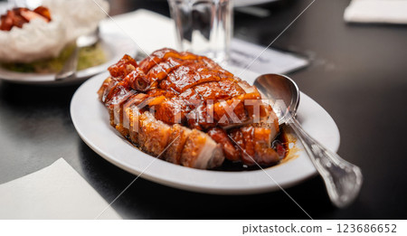 crispy pork and roasted duck is served with a caramelized glaze, embodying authentic Chinese barbecue flavors. 123686652